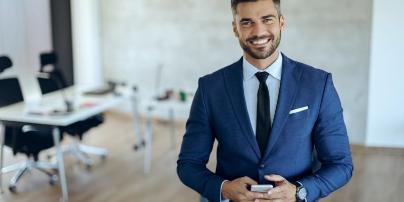 portrait-happy-businessman-with-smart-phone-office (2)